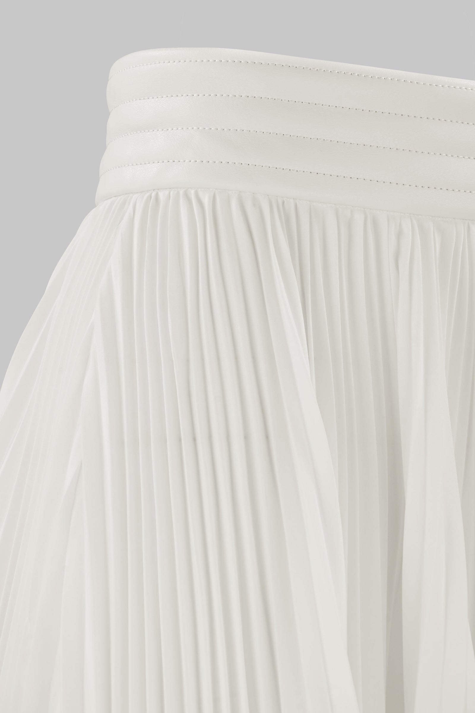 ASYMMETRIC PLEATED SKIRT W/ VEGAN LEATHER WAIST